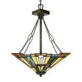 The Inglenook 3 Light Large Tiffany Pendant in Valiant Bronze showcases a stunning stained-glass chandelier with a geometric design featuring shades of blue, green, amber, and red. It is elegantly suspended from a metal rod and chains.