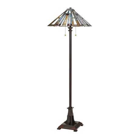 The Maybeck 2 Light Tiffany Floor Lamp in Valiant Bronze features a tall design with a stained glass shade showcasing vibrant geometric patterns. It includes a dark metal base and two pull chains for the light switch, all presented against a plain white background.