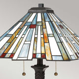 The Maybeck 2 Light Tiffany Table Lamp, featuring a geometric design with handcrafted glass panels in white, blue, orange, and red, includes a valiant bronze base and is equipped with two pull chains for easy operation.
