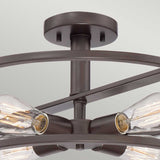 A detailed view of the New Harbor 4 Light Semi-Flush in Western Bronze reveals four Victorian Edison-style bulbs with visible filaments, all encased in a circular metal frame that highlights its rich, industrial appeal.