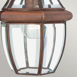 The Newbury Outdoor 1 Light Medium Chain Pendant in a lacquered aged copper finish showcases a vintage-style lantern. It features clear glass panels that reveal the inner bulb, casting a warm glow. Its classic design includes a slightly rounded shape with metal accents and boasts an IP23 rating for durability.