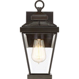 The Ravine Outdoor Small Wall Lantern in a Western Bronze finish enhances the charm of any outdoor decor. Featuring a classic black metal frame with clear glass panels, it elegantly displays a vintage-style exposed bulb and includes a convenient loop on top for easy mounting.