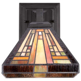 The Stephen 1 Light Tiffany Wall Light in Vintage Bronze showcases a stained glass wall sconce with an angular, geometric design in earthy tones of brown, orange, and cream. Its black metal base enhances the intricate, art deco-inspired glass pattern, capturing the timeless elegance of the Arts & Crafts Movement.