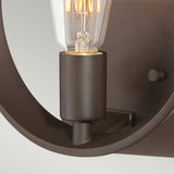 Close-up of the Theatre Row 1 Light Wall Light in Western Bronze, featuring an industrial-style design with a sleek black metal holder and an exposed bulb. The light is off, emphasizing the intricate design of the bulb’s filaments, reminiscent of vintage theatre lighting.