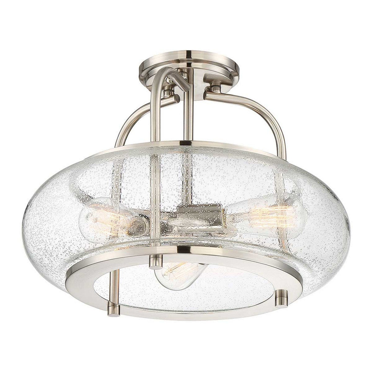 The Trilogy 3 Light Semi-Flush in Brushed Nickel is a modern ceiling light fixture featuring a round seeded glass shade. It showcases three LED filament bulbs within the glass, offering an industrial and contemporary style.