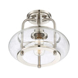 The Trilogy 1 Light Semi-Flush in Brushed Nickel features a modern design with a brushed nickel finish. It boasts a clear, seeded glass bowl-shaped shade adorned with tiny bubbles, which elegantly reveals an Edison-style LED filament bulb inside.