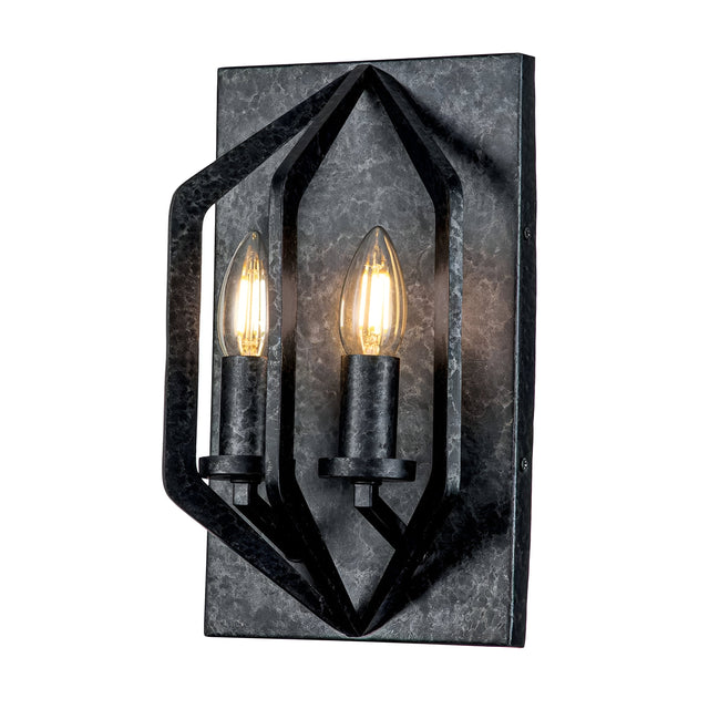 The Vanguard 2 Light Wall Light - Old Black features an industrial-inspired design, complete with a black geometric wall sconce and two candle-shaped bulbs. It is mounted on a rectangular metal backplate with an Old Black finish, and its angular frames beautifully cast a warm glow to enhance any space.