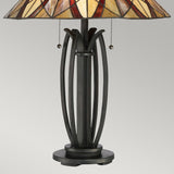 The Victory 2 Light Tiffany Table Lamp in Valiant Bronze boasts a stained glass shade with red and beige geometric patterns. Its base is elegantly finished in valiant bronze, featuring curved metal rods and a round platform, and it offers easy operation with two pull chains.