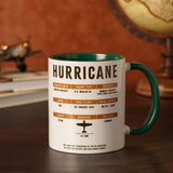 Hurricane Stoneware Mug 11oz, white ceramic with green interior and handle, printed fact sheet and aircraft silhouette, shown on a desk beside a model plane and globe.