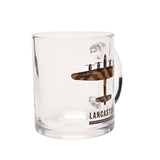 Clear glass mug with a camouflage print of the Lancaster bomber viewed from above, wing roundels in blue and red, and "LANCASTER" printed below, shown on a plain white background.