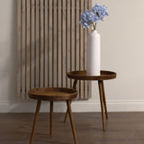 Hill Interiors Light Blue Large Headed Agapanthus stem in a tall white ceramic vase on a round wooden side table beside a slatted wood wall panel.