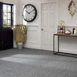 Hill Interiors Dried Sun Big Palm faux stem with fanned beige fronds in a stone vase, styled in a hallway with grey carpet and wall clock.