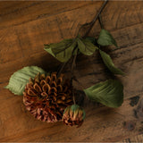 Hill Interiors Deep Mustard Dahlia Stem with layered rust-toned bloom, smaller bud and green leaves resting on a rustic wooden surface.