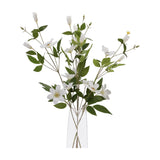 Hill Interiors White Florida Clematis faux flower stems with open white blooms, buds and green foliage arranged in a clear glass vase.