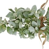 Close-up of Hill Interiors winter spray arrangement with velvety lambs ear leaves, wax flower sprigs and a hessian ribbon bow on a white background.