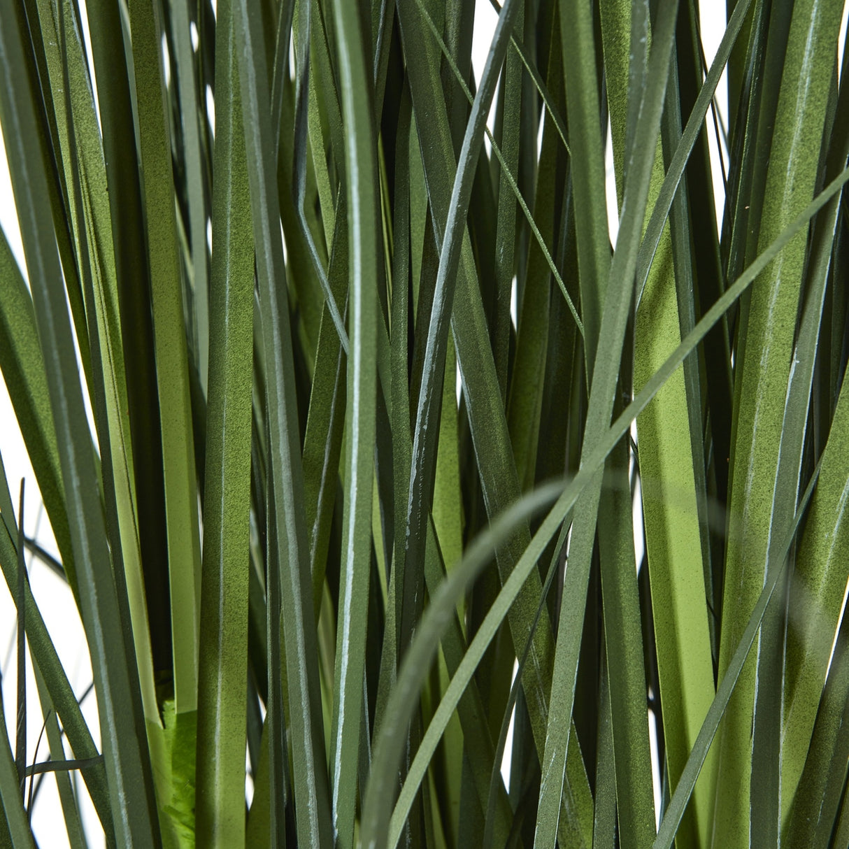 Close-up of the slim green strappy foliage on the Hill Interiors Large Blue Agapanthus faux potted plant, shown against a plain white background.