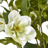 Close-up of Hill Interiors White Hellebore faux plant showing a cup-shaped bloom with pale petals, green veining and yellow stamens among deep green leaves.