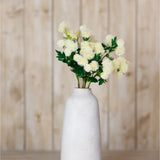 Hill Interiors Cream Globe Thistle Spray with rounded spiky florets and green foliage arranged in a tall white ceramic vase against a wooden panel backdrop.