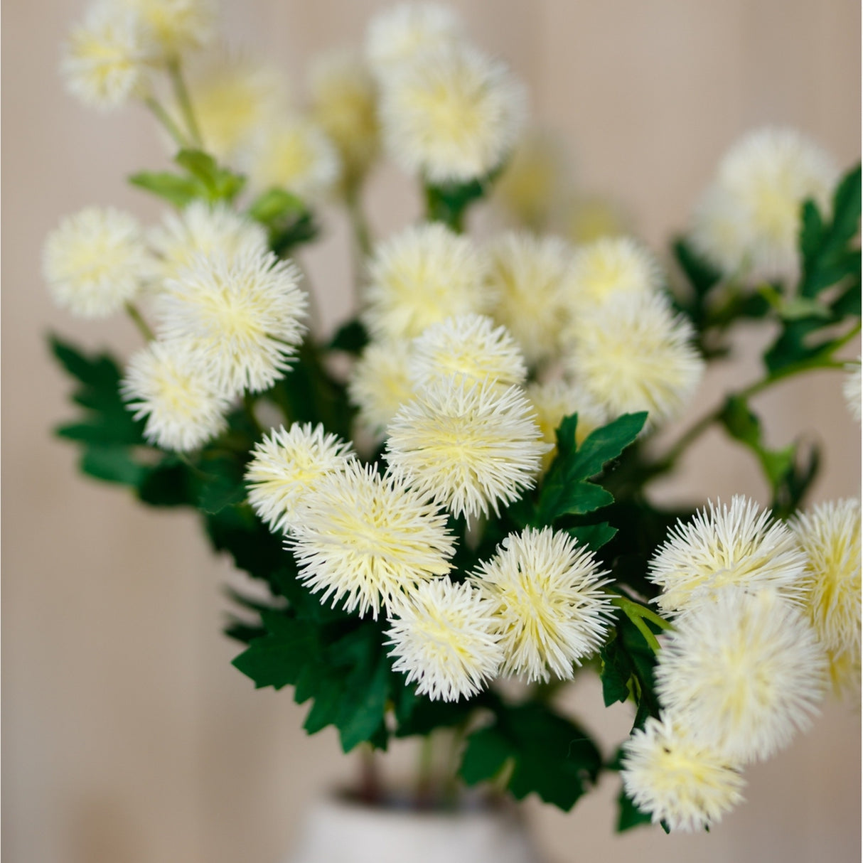 Hill Interiors Cream Globe Thistle Spray with rounded spiky cream florets and slim green leaves, displayed against a soft neutral background.