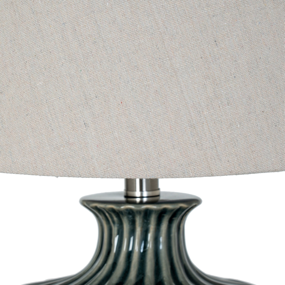 Close-up of the ribbed dark ceramic base and natural linen drum shade of a Hill Interiors table lamp.