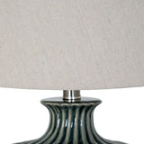 Close-up of the ribbed dark ceramic base and natural linen drum shade of a Hill Interiors table lamp.