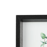 Close-up of the Renabie black photo frame's corner, showing its deep box profile, wood-textured finish, and glass front over a botanical print, against a white background.