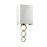 The Ria Small 1 Light Wall Light in aged brass features a modern design with a rectangular ivory faux silk shade and a geometric base with interlocking hexagonal shapes.