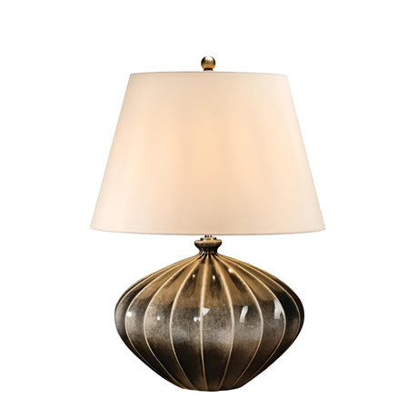 The Rib Pumpkin 1 Light Table Lamp - Brown and Black showcases a wide, round base with a ribbed design in a textured bronze finish. It features vertical grooves and a shiny appearance, complemented by an elegant white tapered faux silk shade topped with a small brass finial.