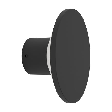 Rigosa LED Outdoor Wall Light in black, side view showing a round steel disc on a cylindrical mount with a slim white diffuser ring, set against a plain white background.