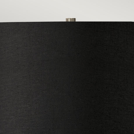 Close-up of the Ripple 1 Light Table Lamp featuring a black shade with a slightly textured surface. The top of this modern lamp showcases a small, metallic finial against a neutral background, blending seamlessly into your contemporary lighting setup.