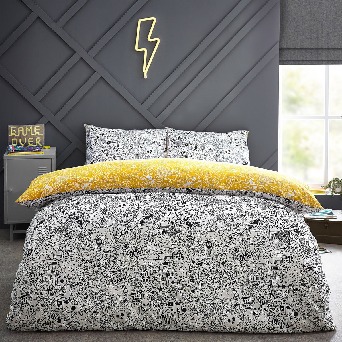 Doodles Polycotton Printed Duvet Cover Set in white/black with dense black doodle print, reversible to yellow, shown on a bed with matching pillowcases in a bedroom setting.