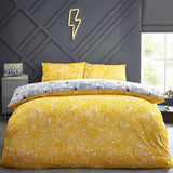 Reversible Doodles polycotton duvet cover set on a bed, showing the yellow doodle-print side with matching pillowcases in a bedroom setting.