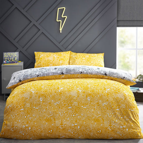 Reversible Doodles polycotton duvet cover set on a bed, showing the yellow doodle-print side with matching pillowcases in a bedroom setting.