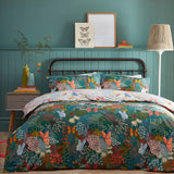 Forage Printed Floral Duvet Cover Set in teal on a bed with matching pillowcases, featuring coral, blue and amber butterflies and floral patchwork print, styled in a teal-panelled bedroom.