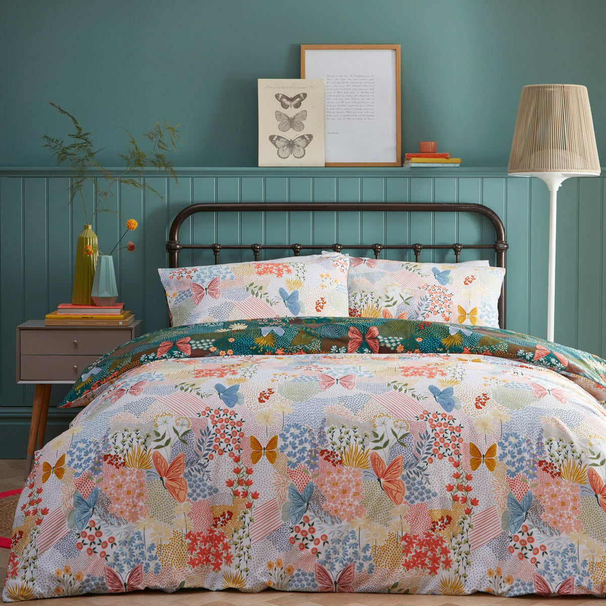 Teal Forage Printed Floral Duvet Cover Set with matching pillowcases, featuring butterflies, flowers and grasses in coral, blue and amber on a teal-green ground.