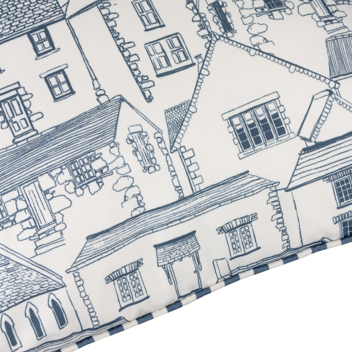 Close-up of the Abersoch Town Reversible Polyester Cushion showing hand-drawn blue line illustrations of cottages and rooftops on white fabric, edged with a blue and white striped piped trim.