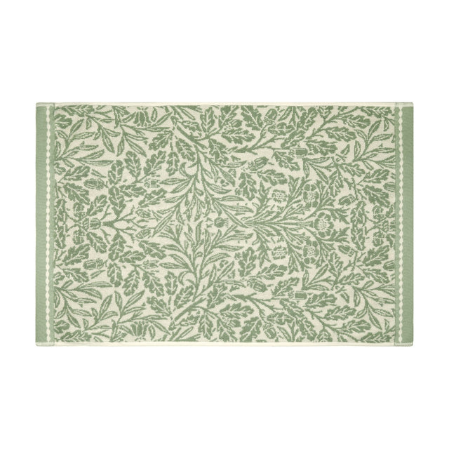 Acorn Floral Cotton Bath Mat in sage green, woven with an oak leaf and acorn design on a cream ground, framed by a plain green border, shown on a white background.
