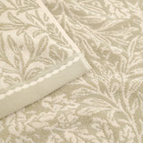 Close-up of an Acorn Jacquard Cotton Towel in natural beige, showing the woven acorn and oak-leaf pattern with a scalloped braid border.