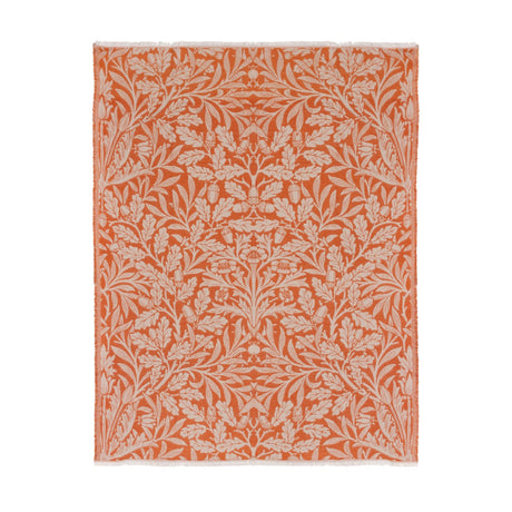 Acorn Tonal Jacquard Cotton Blend Throw in brick orange, woven with a cream botanical pattern of oak leaves and acorns, shown with fringed edges on a plain white background.