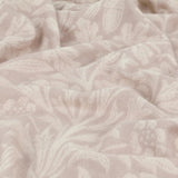 Close-up of the Acorn Tonal Jacquard Linen Throw in beige, showing a woven oak leaf and acorn pattern in soft tonal shades across the draped linen fabric.