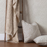 Acorn Tonal Jacquard Linen Throw in beige, draped over a wooden ladder beside matching leaf-patterned cushions and botanical wallpaper.