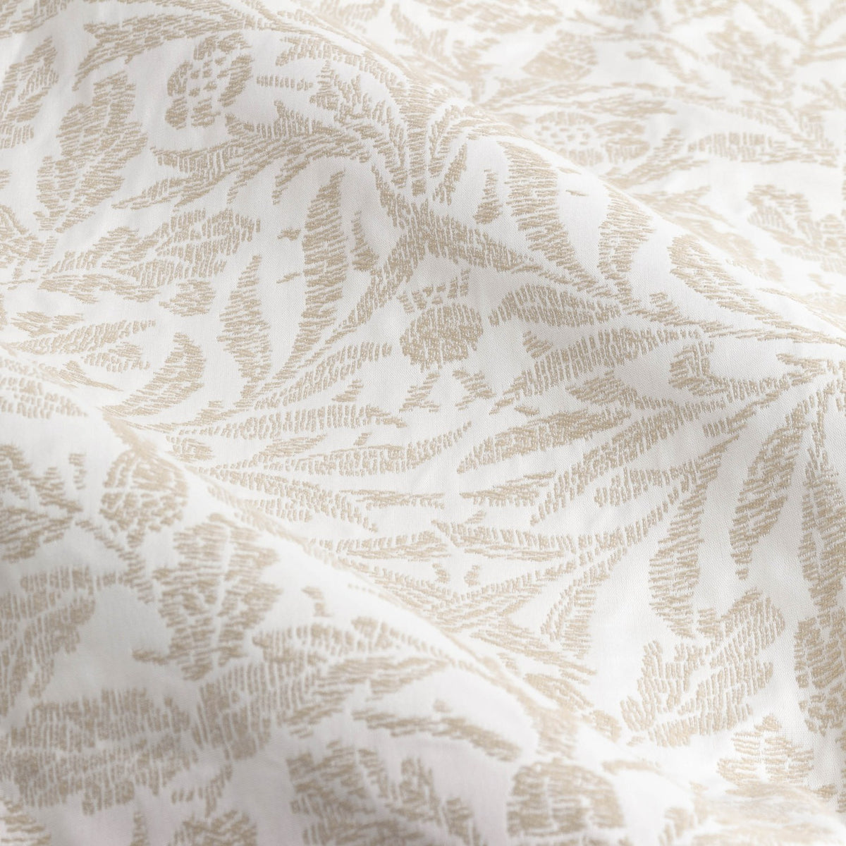 Close-up of the Acorn Tonal Jacquard pencil pleat curtain fabric in Willow, showing a woven acorn and oak leaf pattern in cream tones on soft draped polyester cloth.