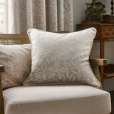 Square Acorn Tonal Jacquard Linen Cushion in cream with woven leaf and acorn pattern and corded edge trim, shown on an armchair in a living room setting.
