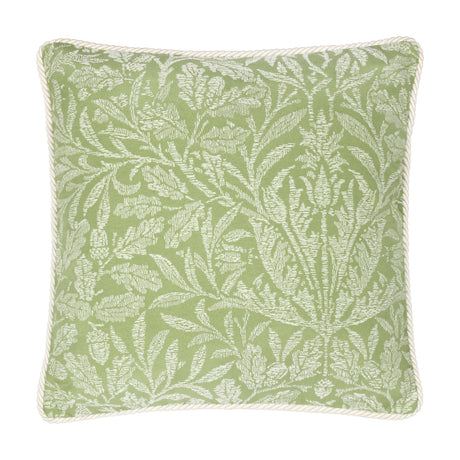 Square sage green cushion with a tonal jacquard acorn branch pattern in paler leaf tones, finished with cream cord piping, shown on a plain white background.