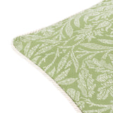 Close-up of the Acorn Tonal Jacquard cushion in sage, showing woven acorn branch pattern in pale tones with a corded ivory edge trim on a plain white background.