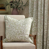 Acorn Jacquard Chenille Pencil Pleat Curtains in Stone/Sage shown in a living room, with matching cushion in acorn and oak leaf pattern on a beige armchair.