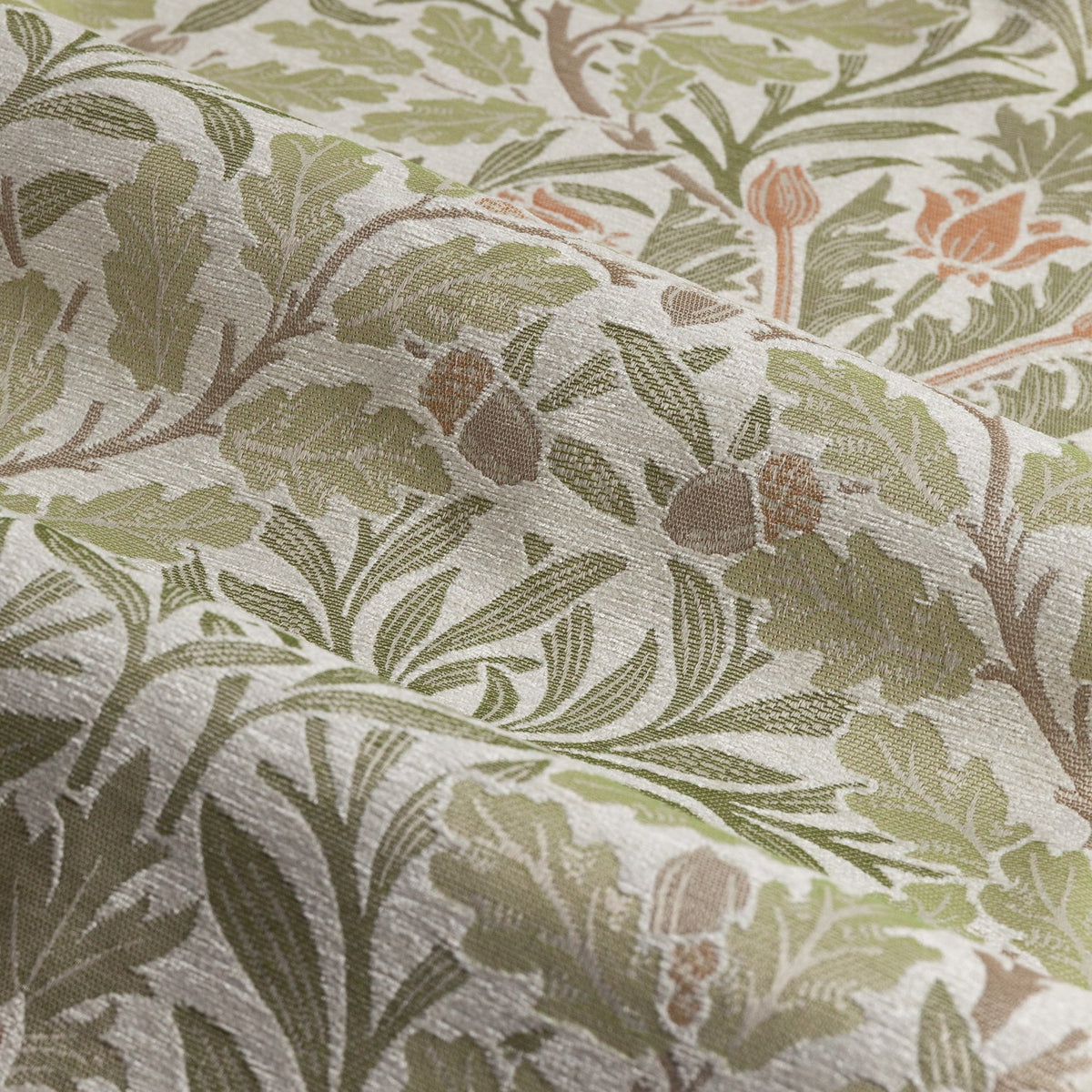 Close-up of Acorn Multi Jacquard Chenille pencil pleat curtain fabric in stone/sage, showing woven oak leaves, acorns and trailing stems in green, brown and orange tones.