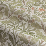Close-up of Acorn Multi Jacquard Chenille pencil pleat curtain fabric in stone/sage, showing woven oak leaves, acorns and trailing stems in green, brown and orange tones.