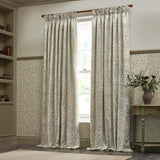 Pencil pleat curtains in Acorn jacquard chenille, stone/sage foliage pattern, shown pleated on a wooden pole beside a window in a study setting.