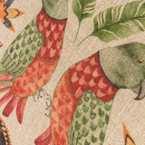 Close-up of the Akamba Animal Linen Cushion showing hand-painted parrots in green and coral plumage with jungle leaf motifs on a natural polyester ground.